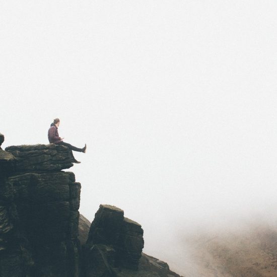 A man sitting on a high cliff.