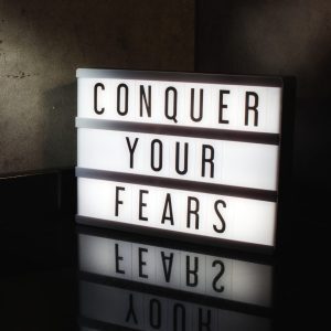 A lighted sign that says "conquer your fears".