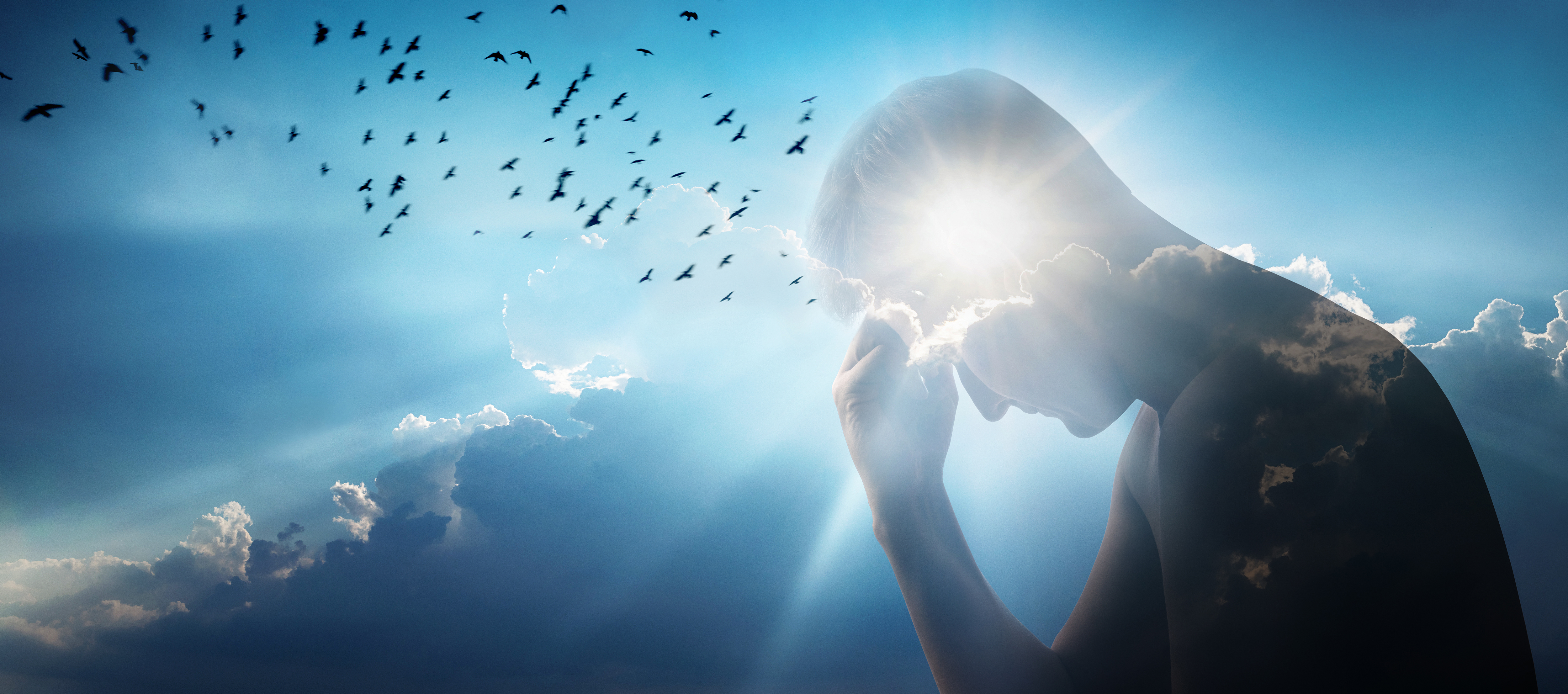 Silhouette of a man holding his head in distress, blended with a bright, cloudy sky and birds flying overhead, symbolizing emotional struggle and hope.