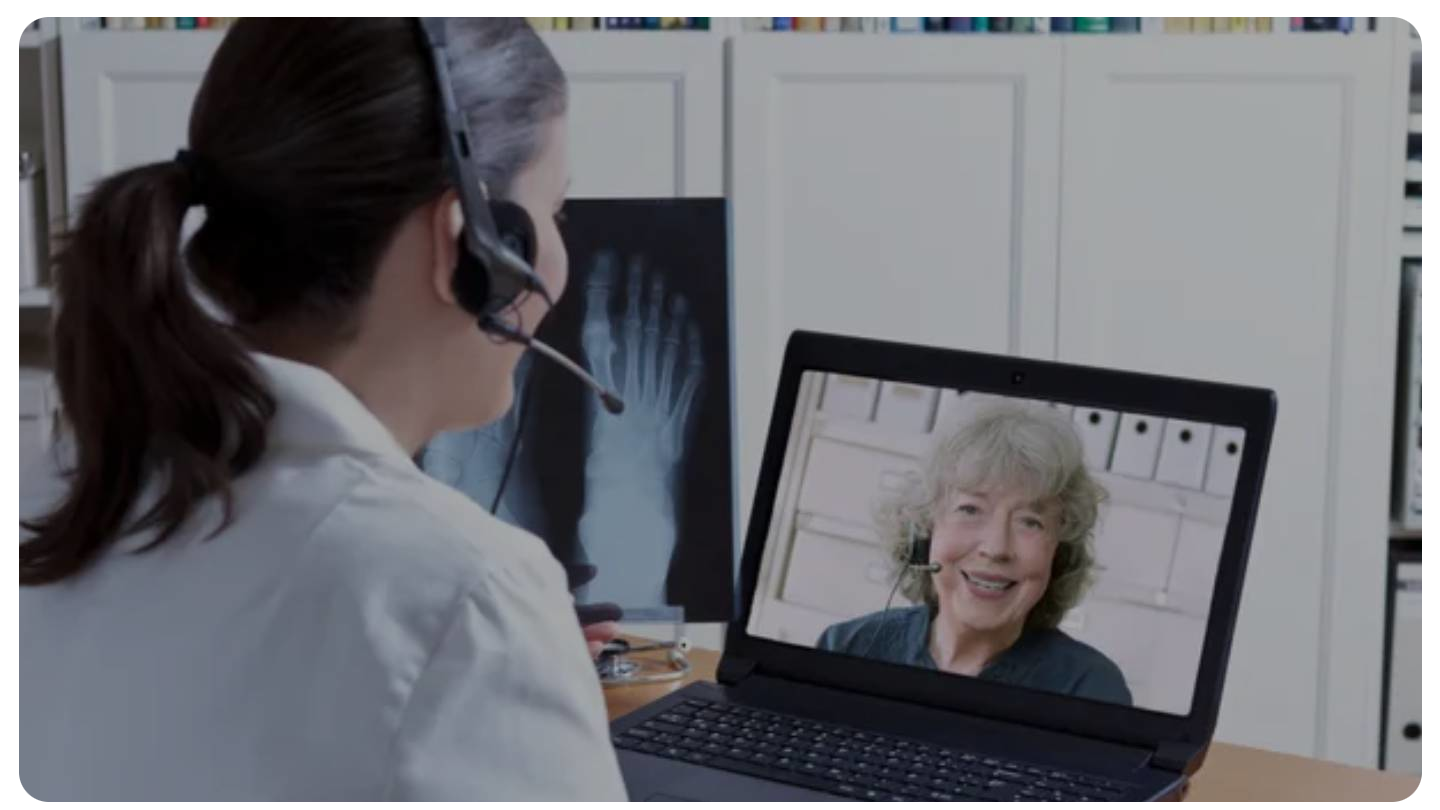 A person having a psychiatric consultation, talking with a therapist on a laptop.