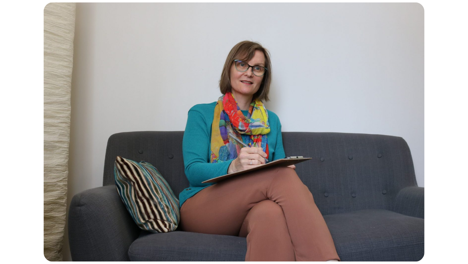 lady-smiling-sitting-down-on-gray-couch1