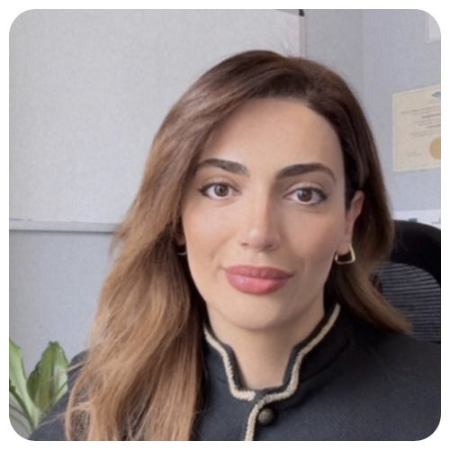 Aytar Atakishiyeva is smiling, wearing a black button blouse with white trim.