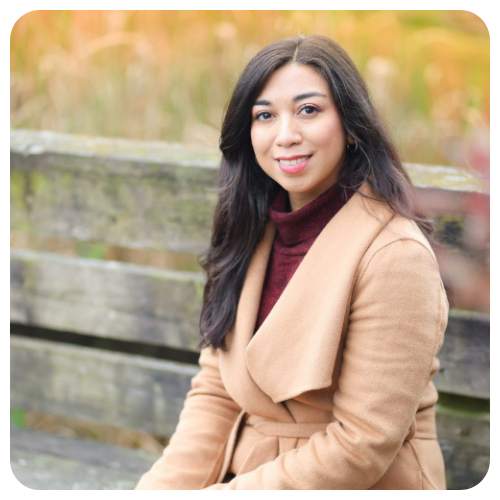 Fatima Tima Meshary is smiling, wearing a tan jacket and a brown turtleneck sweater. Fatima Tima Meshary is smiling, wearing a tan jacket and a brown turtleneck sweater.