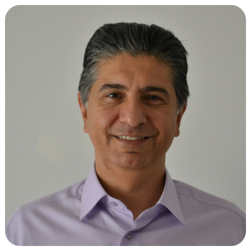 Kasra Hushmand smiling, wearing an off-white collared shirt.