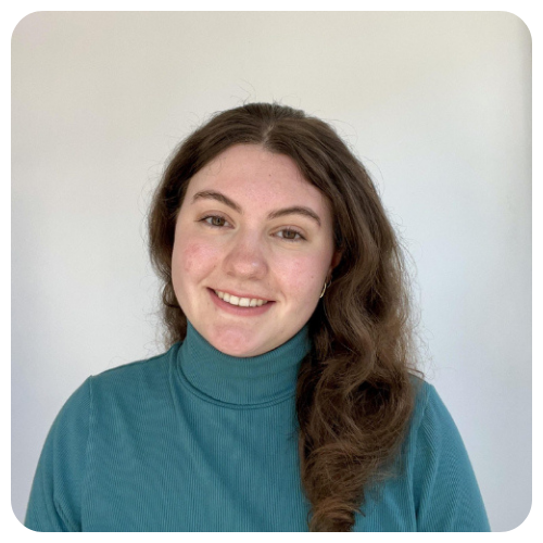 Lindsey Hapli is smiling, wearing a turquoise turtleneck sweater.