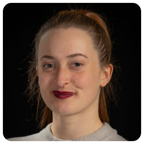 Ocean Dinel smiling in a professional headshot against a dark background, wearing a light-colored top.