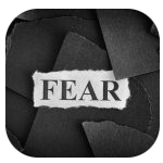 black scrap pieces of paper with a white scrap paper saying "fear" over them, black scrap pieces of paper with a white scrap paper saying "fear" over them,