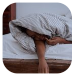 A lady sleeping under a gray and white striped blanket. A lady sleeping under a gray and white striped blanket.